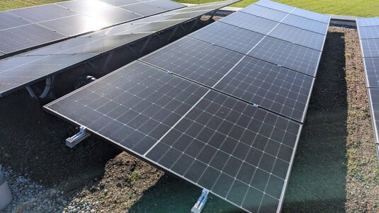 Extensive Dachbegrünung kombiniert mit effizienter PV‑Anlage; klimaresistente Sedum‑Bepflanzung verbessert Kühlung und Ertrag der Solarmodule für ein nachhaltiges Energiedach.